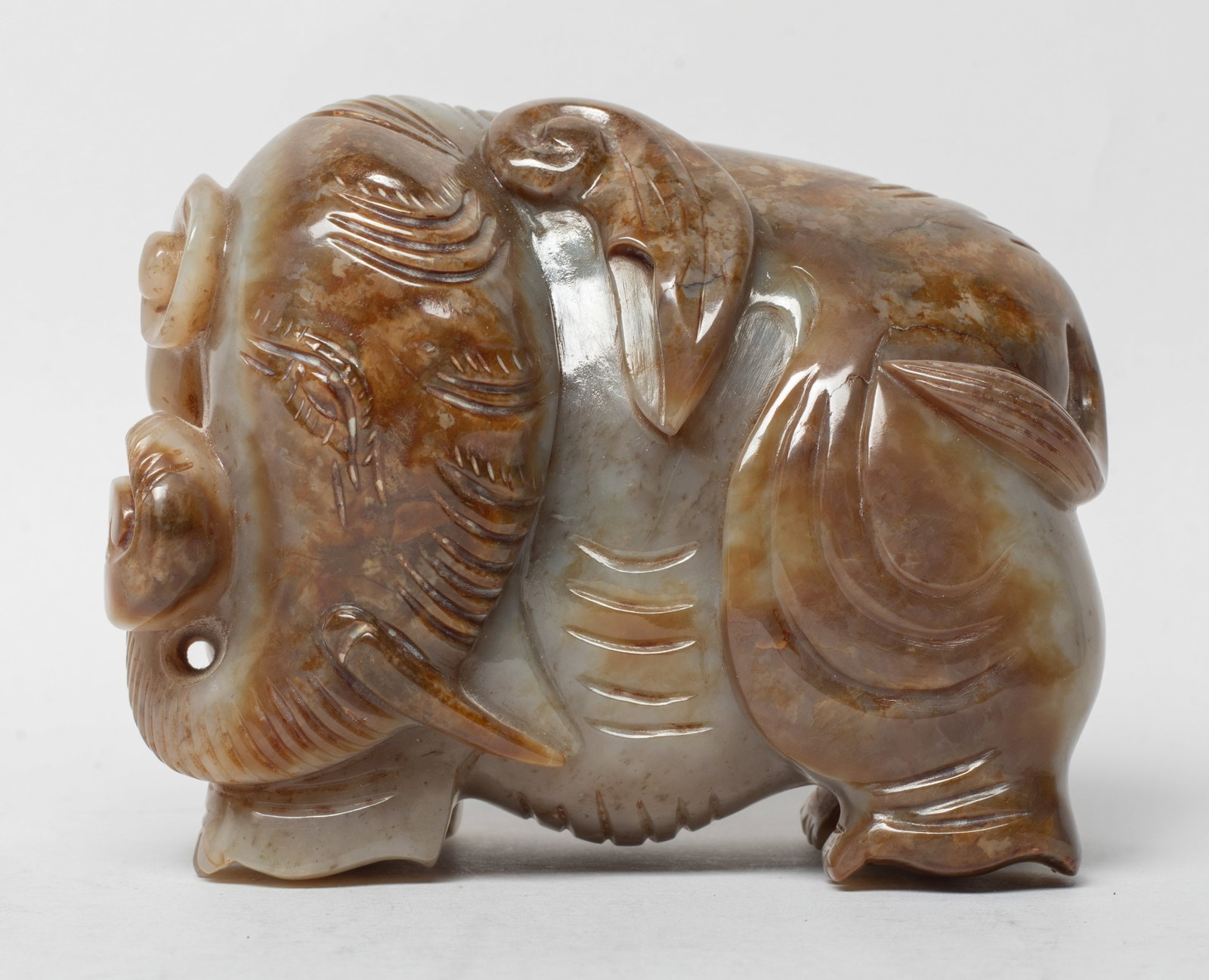 Estate Chinese Russet Jade Sculpture: Carved with a wrinkled elephant with long tusks and head bowed to one side, the toes and underside of the feet well delineated. Approx. 3.9*3*2 inch.