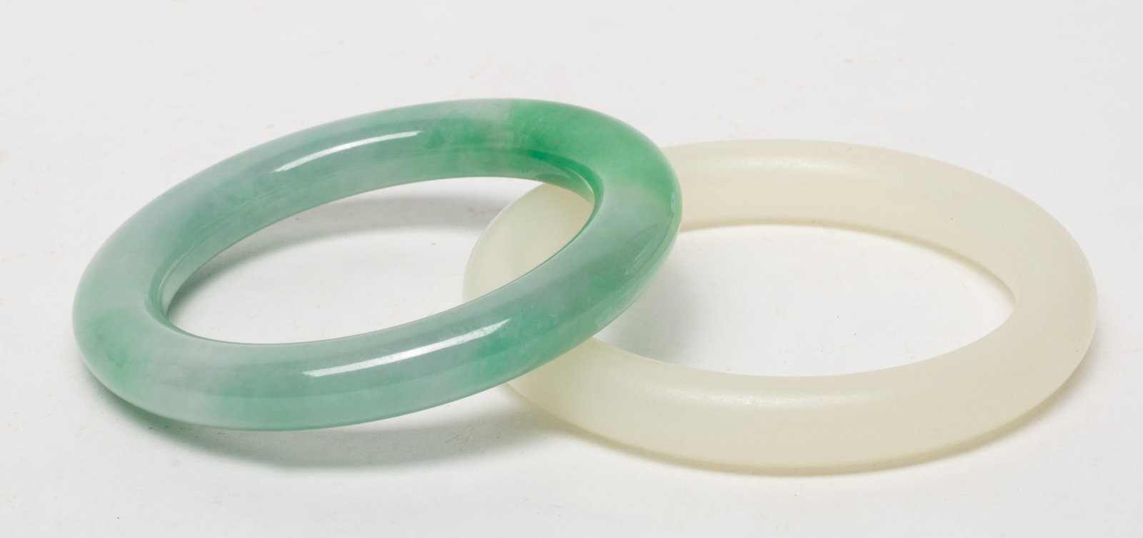 Two Chinese Export Colored Bangles: Two Chinese jade-like colored bangles. Approx. 3.3 inch outer diameter, 2.47 inch inner diameter (larger).