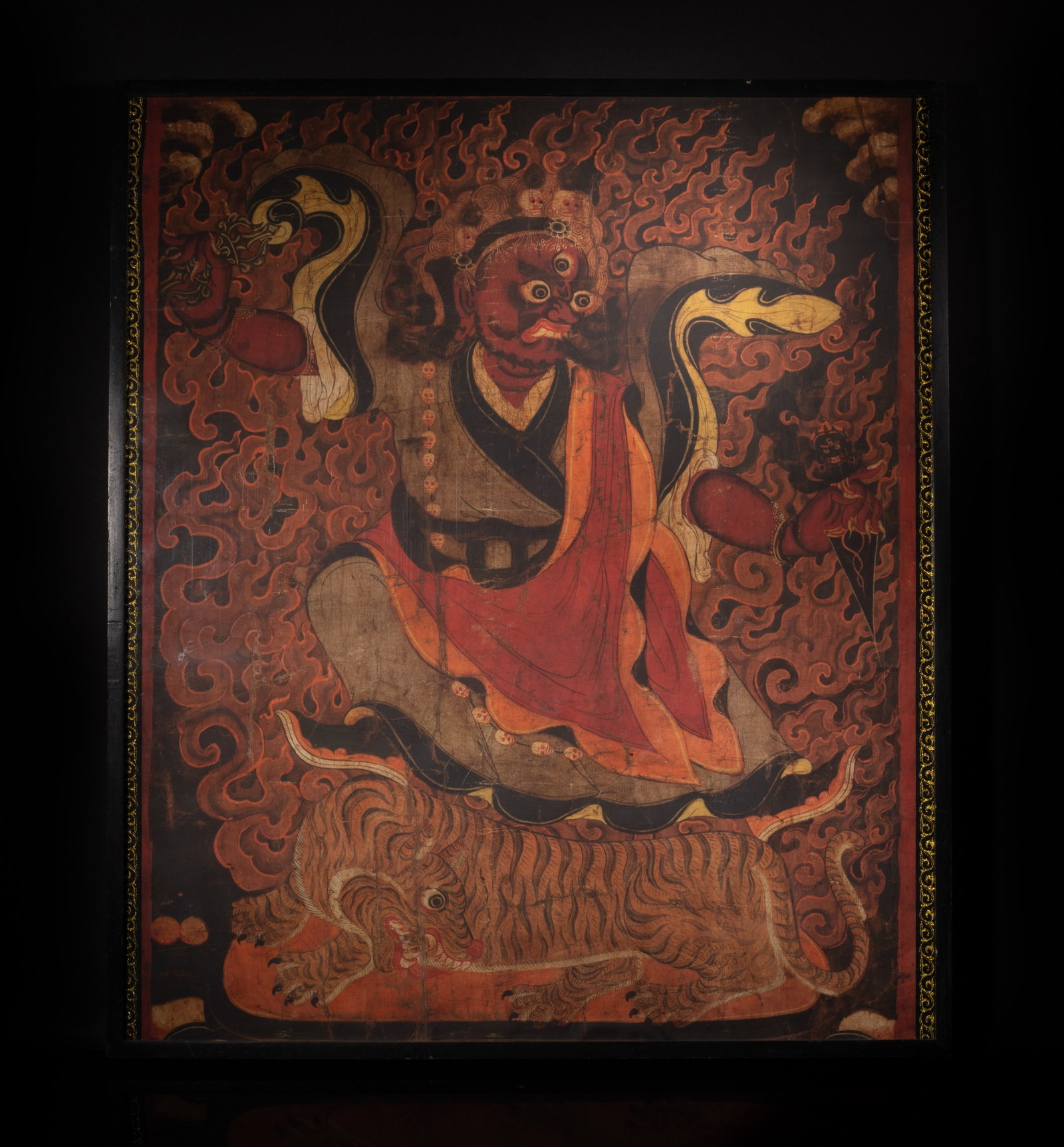 Chinese Wall Hanging Thangka: Depicting a Dorje Drolo with a red color body, three eyes, and a fierce expression, standing atop a tiger. Approx. 25*28.7 inch (w/frame)