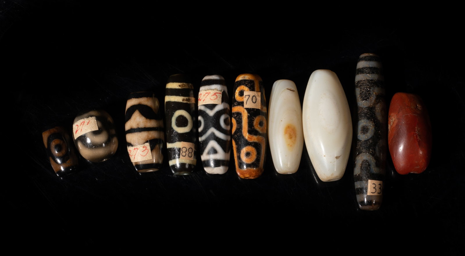 Estate Chinese Tibetan Dzi, Agate Beads: Set of ten Chinese Tibetan dzi beads and agate beads. Approx. 2.28 inch L (longest). The Estate of the Pi Sum Park. Newport Beach. 1995.