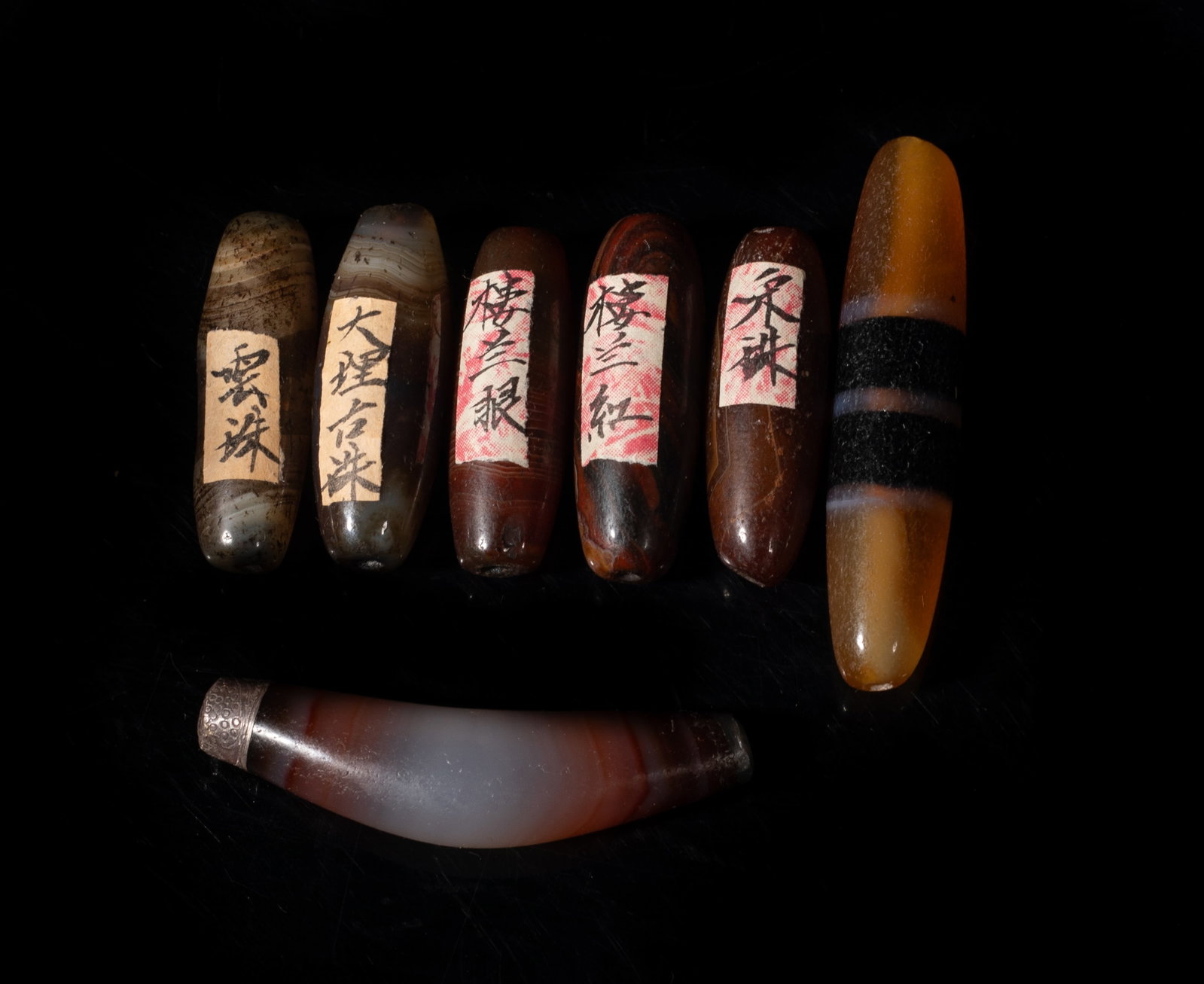 Set Chinese Cameo Banded Agate Beads: Set of seven Chinese banded cameo agate carved beads. Approx. 2.3 inch L (longest). The Estate of the Pi Sum Park. Newport Beach. 1995.