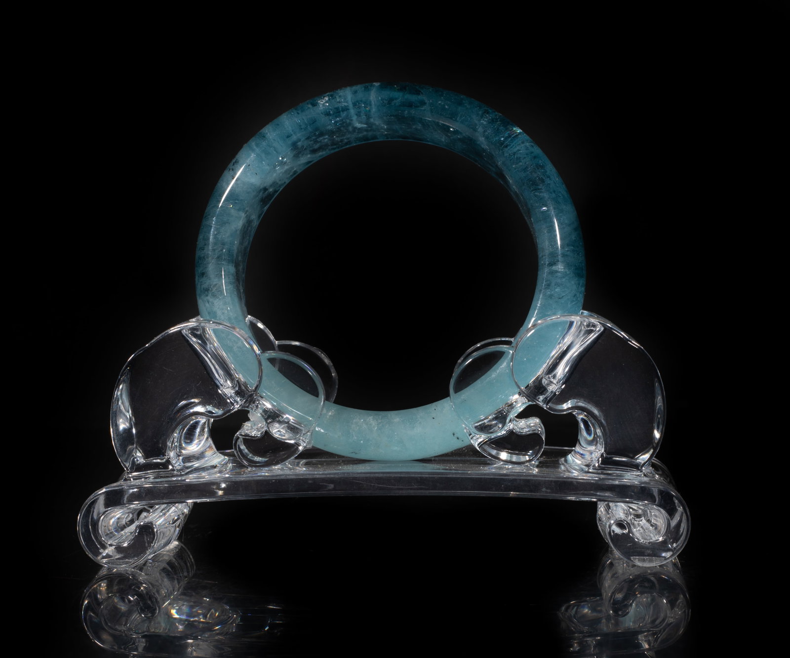High Quality Aquamarine Bangle: High quality aquamarine carved bangle, with stand. Approx. 2.6 inch outer diameter, 2.0 inch inner diameter.