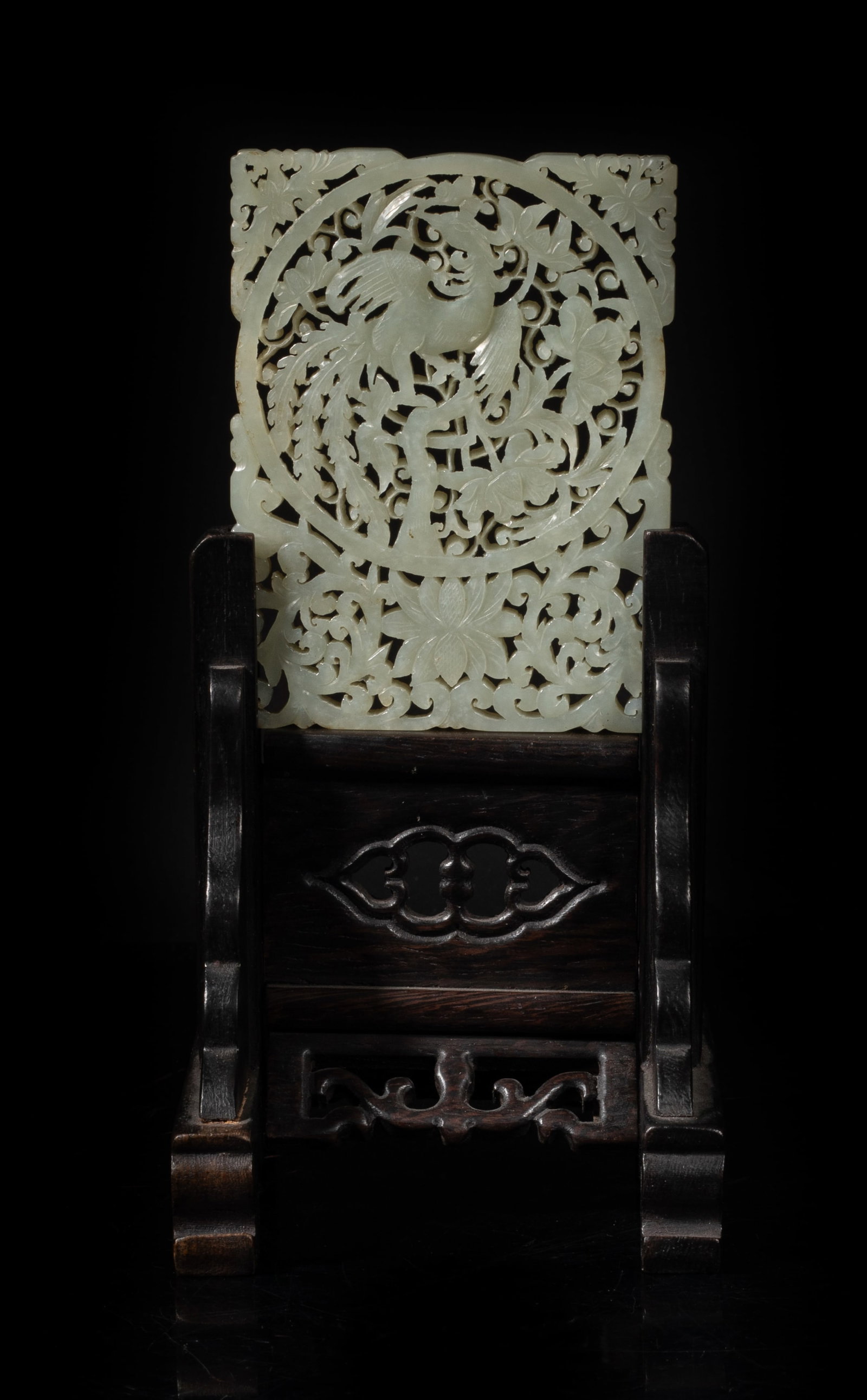 Chinese Jade Carved Table Screen: The jade screen of rectangular form, carved in an openwork depicting a phoenix resting on a blossom stem in central, surrounded by floral motif pattern, supported on a fitted wood stand. Approx. 8*4