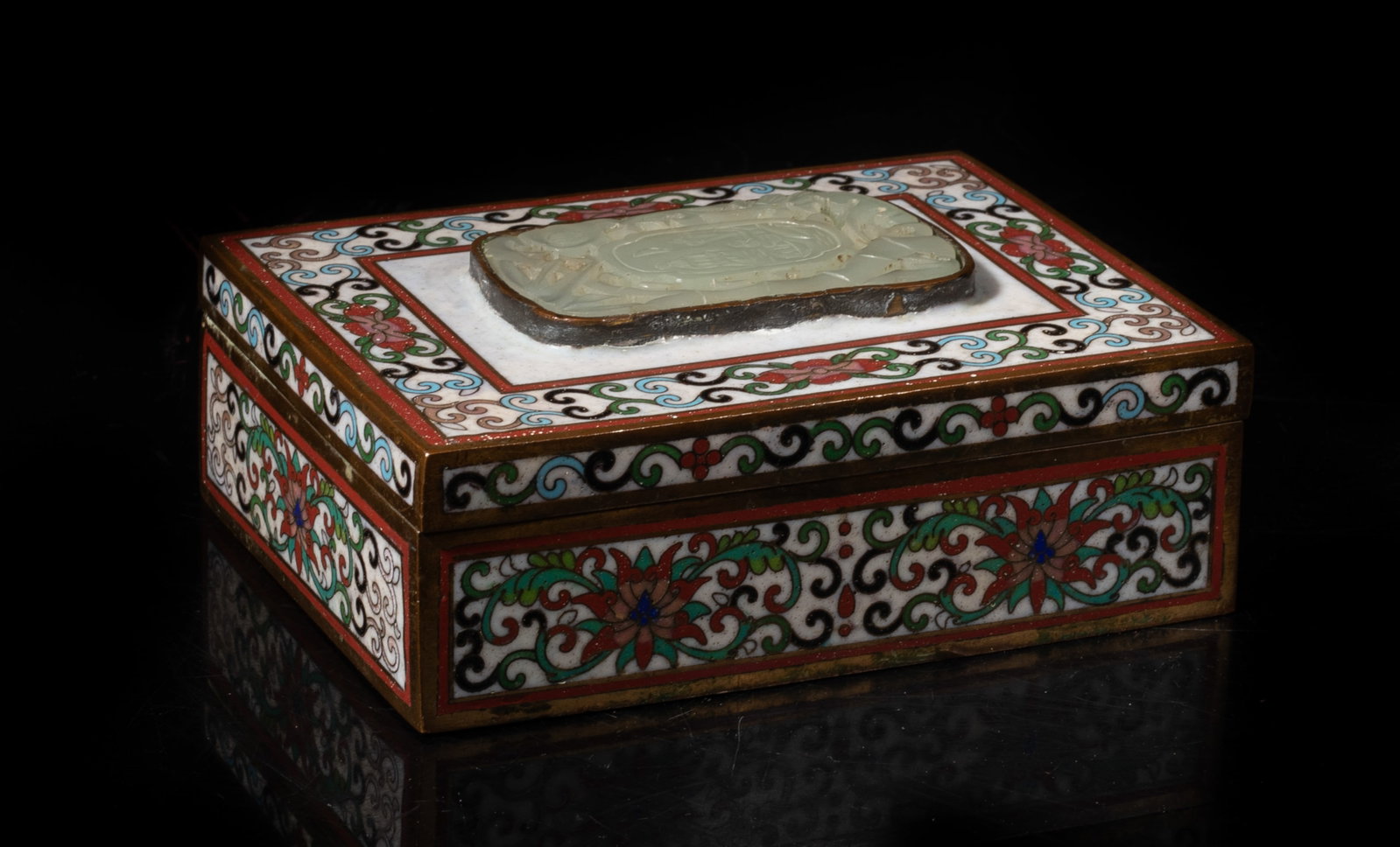 Chinese Cloisonne Box Inlaid Jade Plaque: The cloisoone box of rectangular form, the top inlaid with an openwork form jade plaque, detailed with floral scrolls pattern. Approx. 4.7*1.5*.3.5 inch