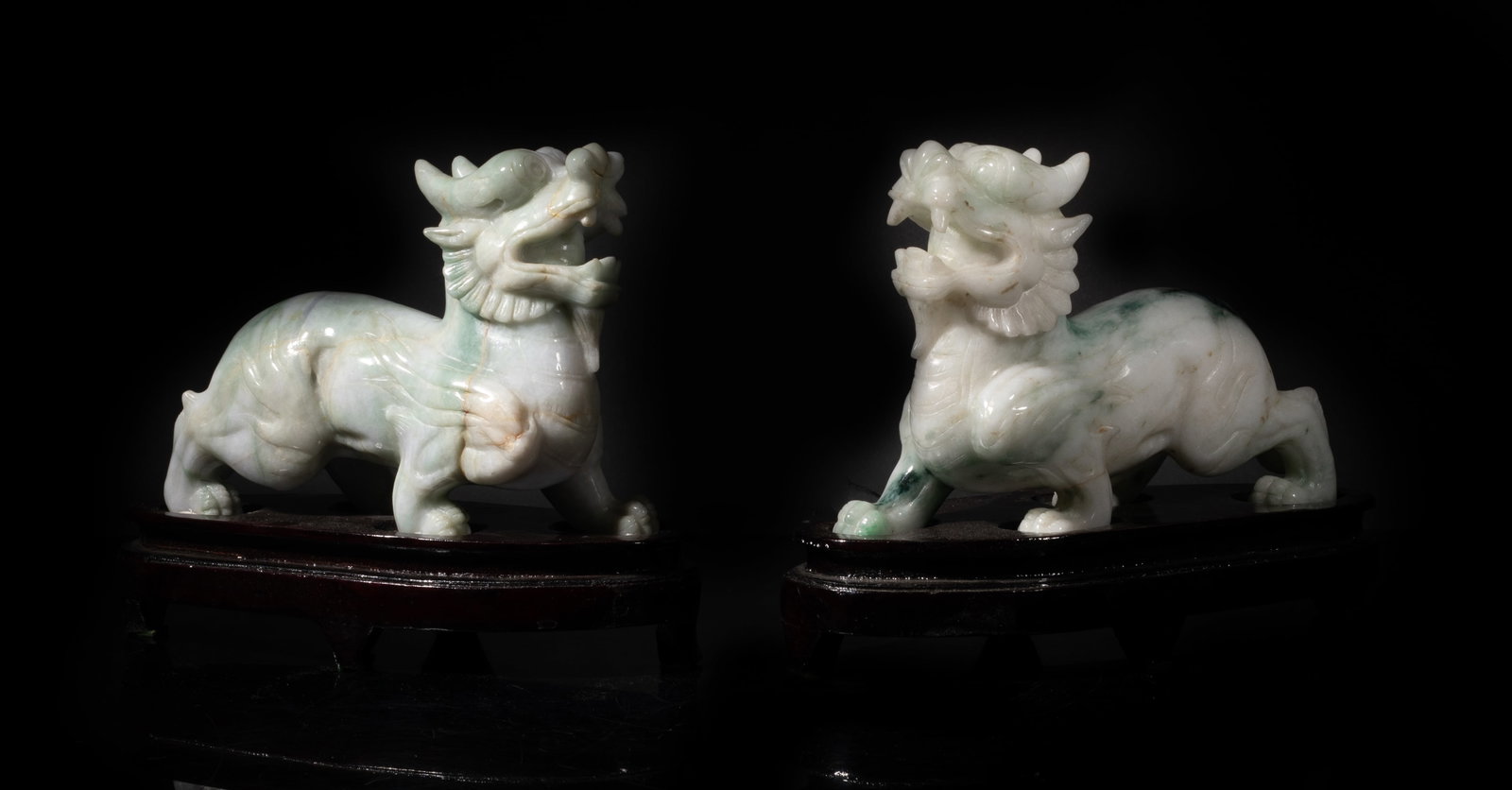 Early 1900s Chinese Jade Jadeite Sculptures: Two Chinese jade jadeite sculptures carved of beast form, with wood bases. Approx. 8.5*3.6*6.6 inch (w/ stand).