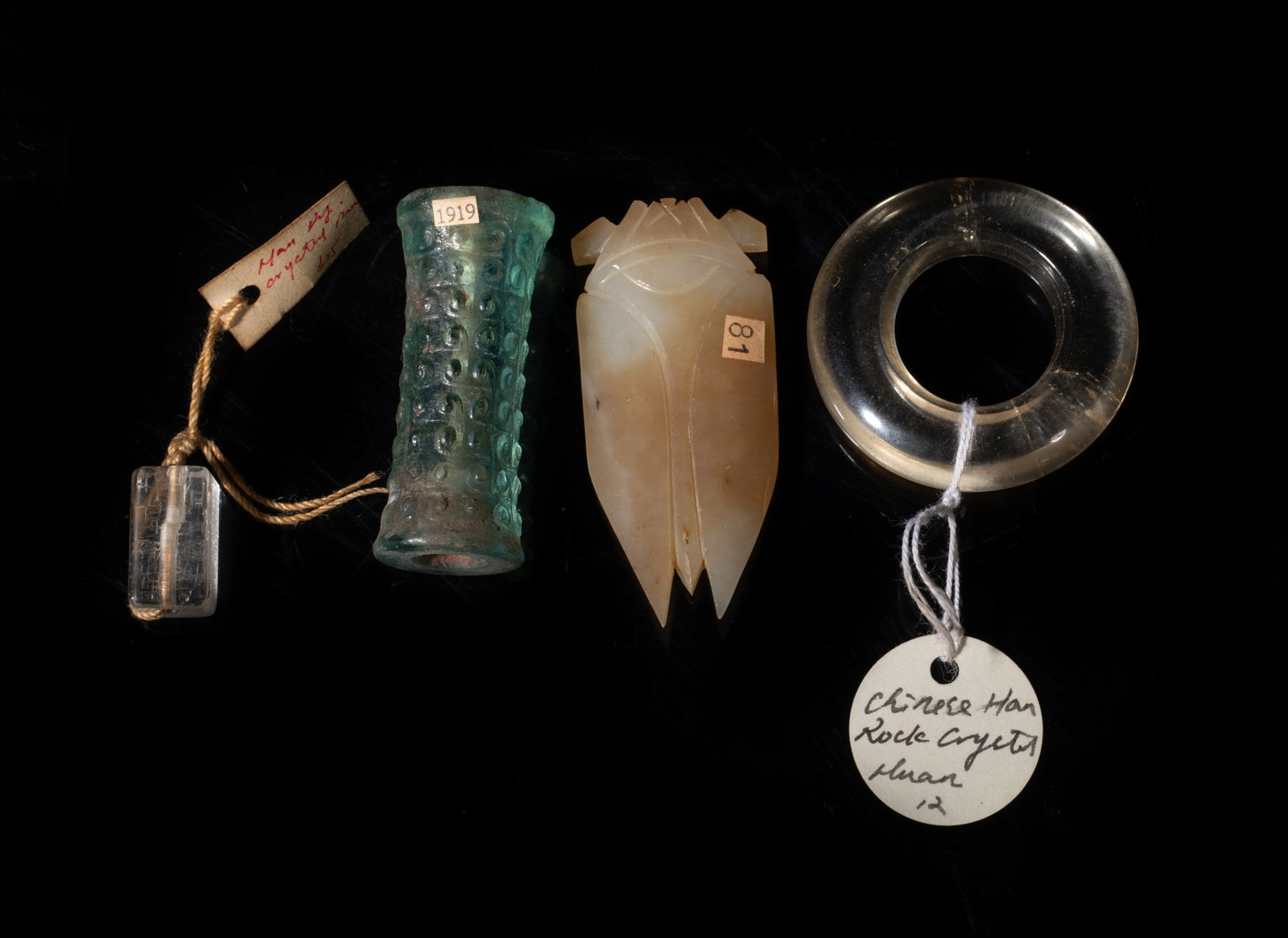 Set Chinese Crystal, Jade, Glass Carvings: Including a jade carved cicada, a large glass bead, a crystal huan, and a crystal bead. Approx. 2.4*1.07 inch (largest). The Estate of the Pi Sum Park. Newport Beach. 1995.