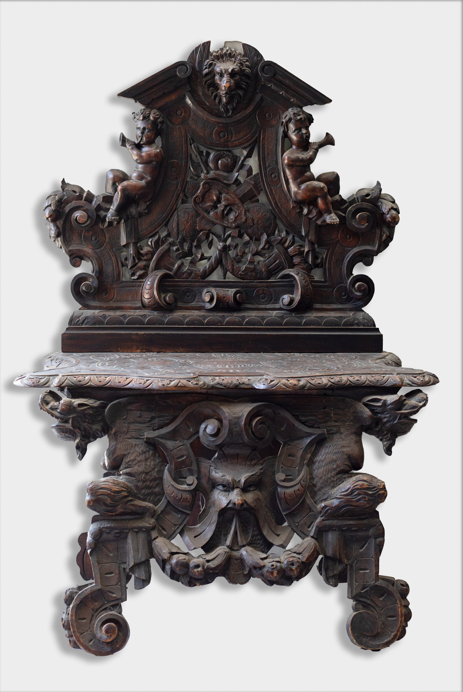Italian Renaissance Revival Walnut Hall Sgabello: Italian Renaissance Revival carved walnut hall bench (sgabello), detailed with winged putti, a lion crest and mask motifs, all carved in high- relief. Approx. 31.25*49*21 inch