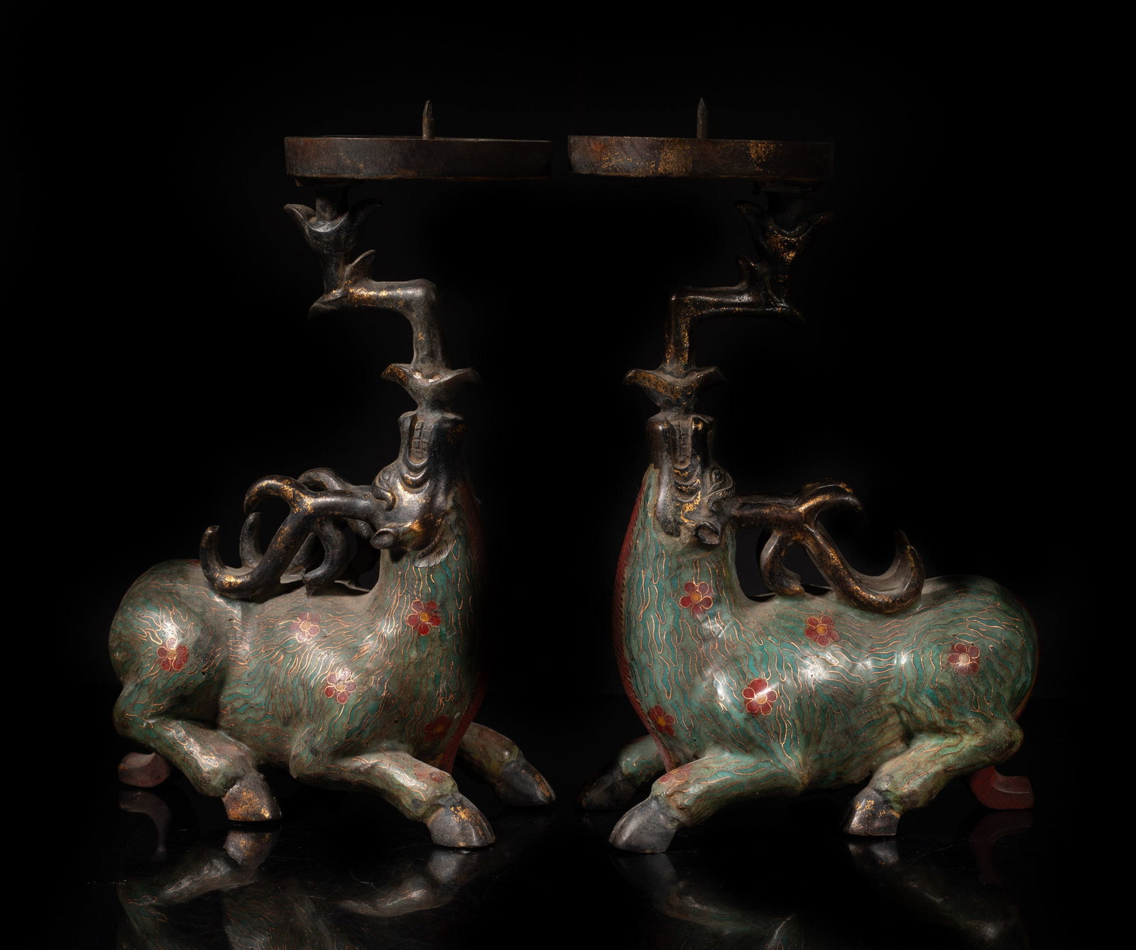 Two Chinese Cloisonne Oil Lamp Sculptures: A pair of Chinese cloisonne oil lamps, each deer is in recumbent position with its chest raised and legs tucked beneath, the oil lamp with a circular drip on atop of the deer's head. Approx. 10*6.7*3 