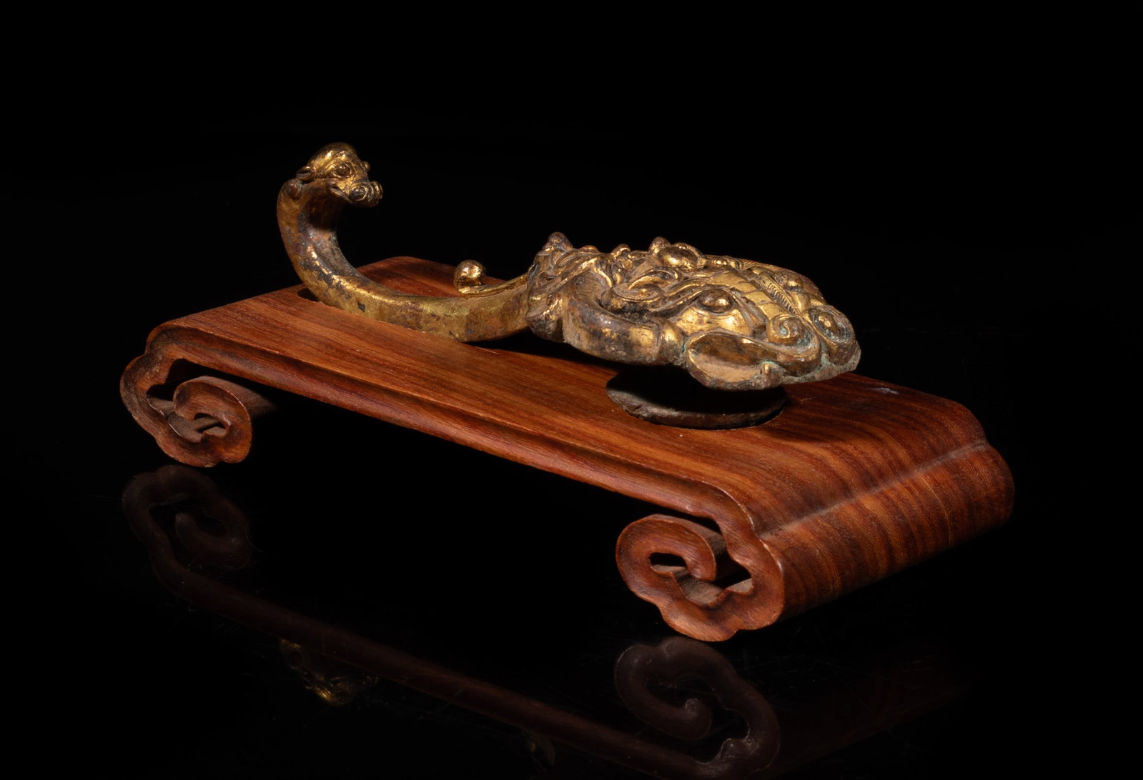 Chinese Gold on Bronze Belt Buckle: Chinese gold on bronze belt buckle, cast with archaistic beasts and mask, affixed to a wood base. Approx. 6.5*2.6*2.1 inch (w/ base). The Estate of the Store Closed Sale, Downtown Los Angeles. 2020.