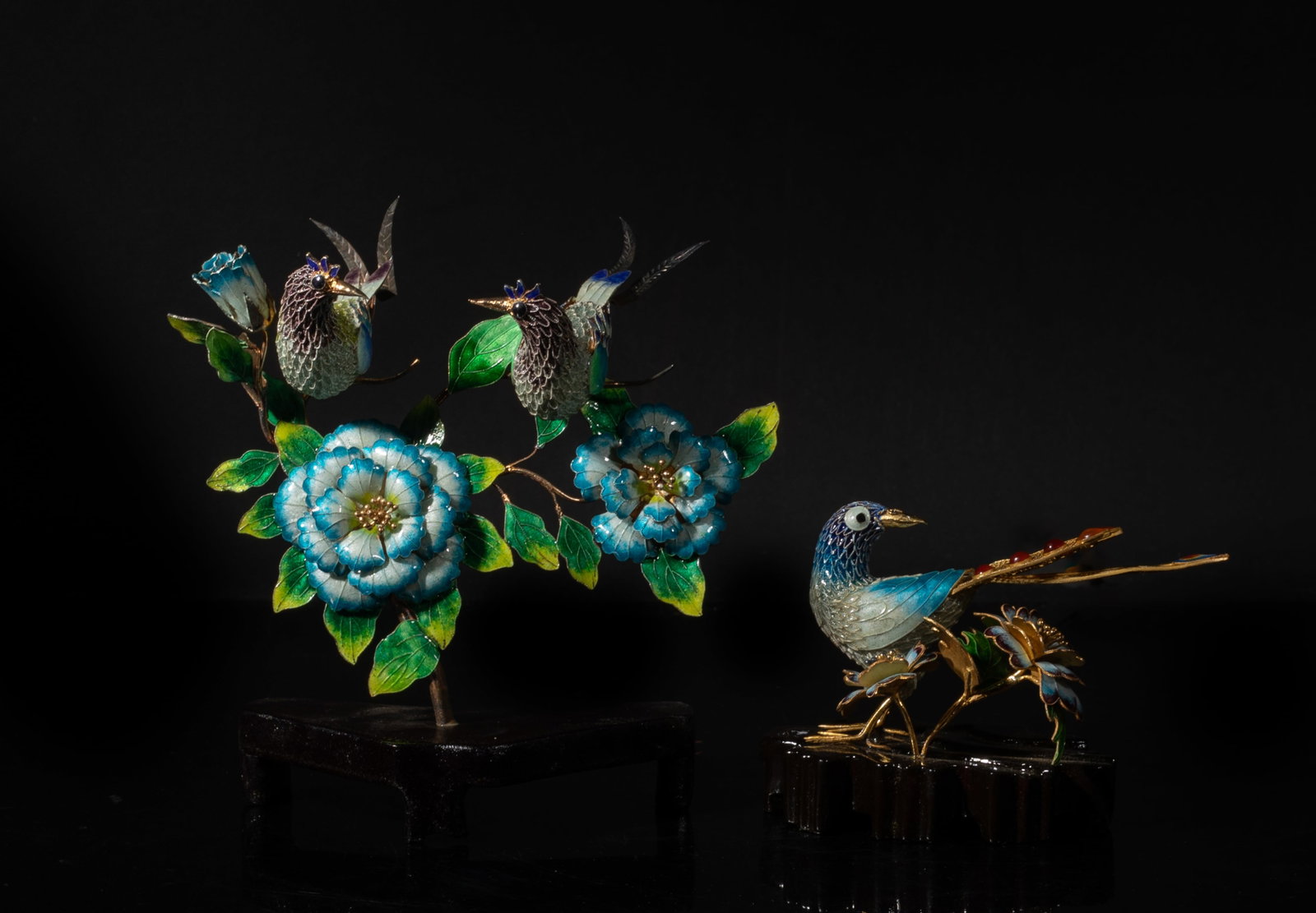Two Chinese Enameled Gold on Silver Sculpture Bird: Two Chinese enameled gold on silver bird sculpture on a wood stand, featuring detailed birds perched among colorful floral and leaf accents. Approx. 5.4*5.7 inch (larger); 211 g (w/stand)