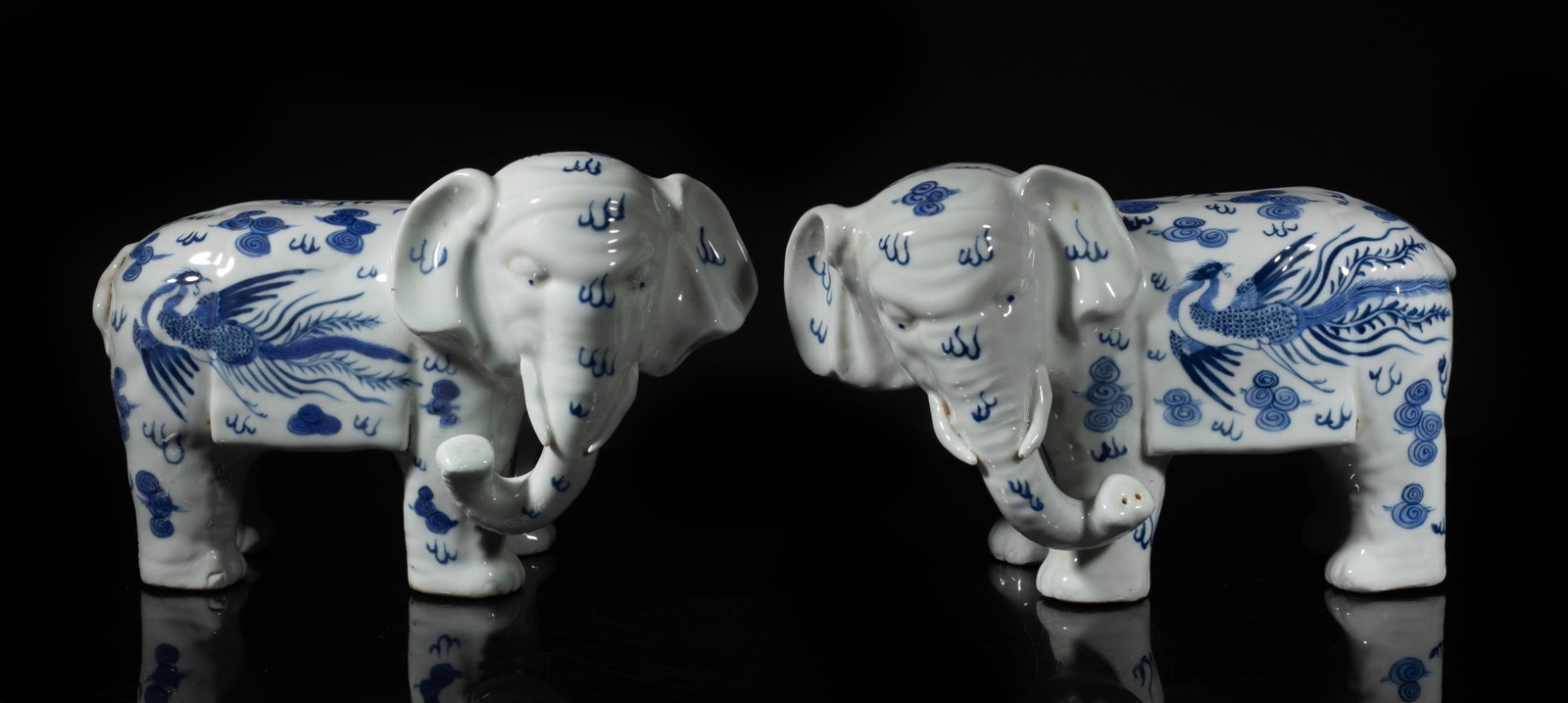 Two Chinese Blue & White Porcelain Sculptures: Two Chinese blue and white porcelain elephant sculptures, painted with dragon and phoenix amidst flames and clouds. Approx. 6.2*9.5*4.2 inch.