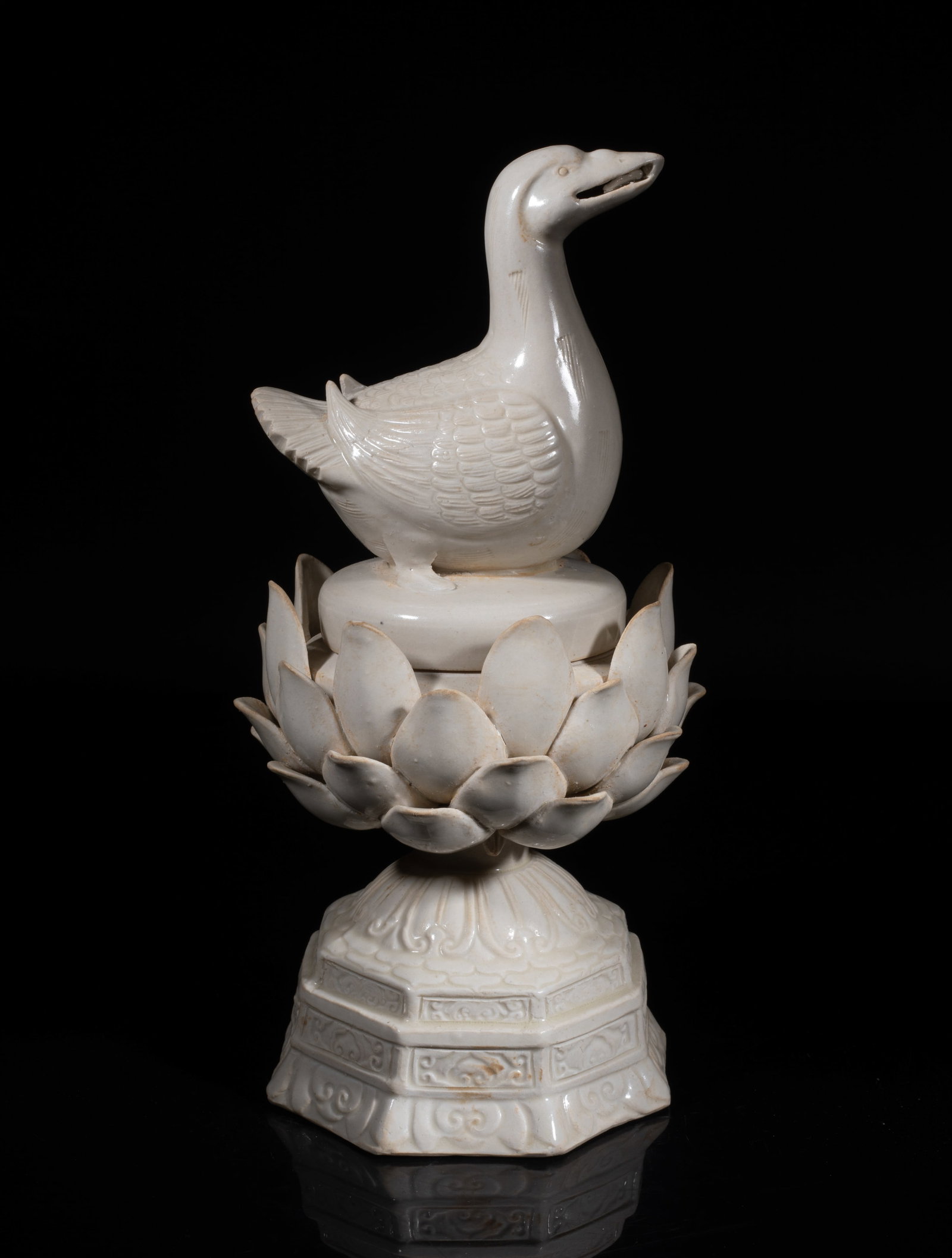 Chinese Ding Ware Porcelain Sculpture: The porcelain vessel moulded in lotus bloom form, resting on a tall spreading foot carved with lotus and ruyi pattern, the lid set with a bird on the top, detailed with finely incised feather. Approx.