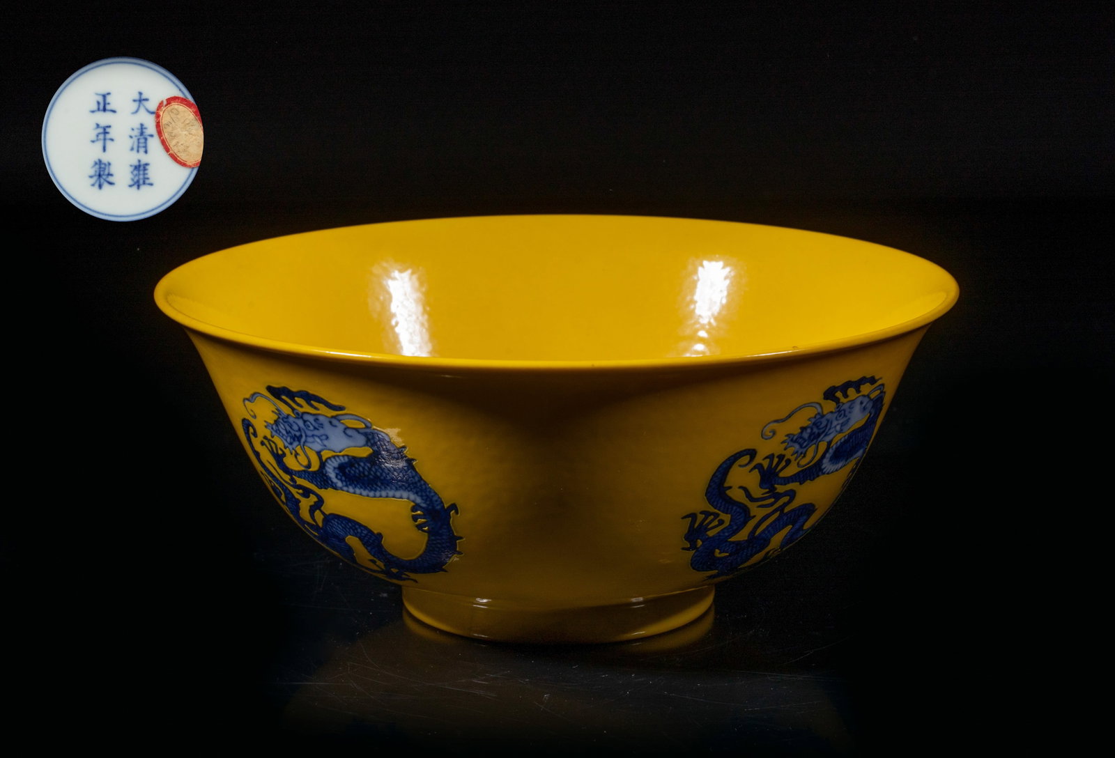 Chinese Export Porcelain Dragon Bowl: The bowl interior center and exterior decorated with cobalt-blue sinuous dragons forming in circular shape against yellow glazed background, the bottom marked with six characters enclosed in double ci