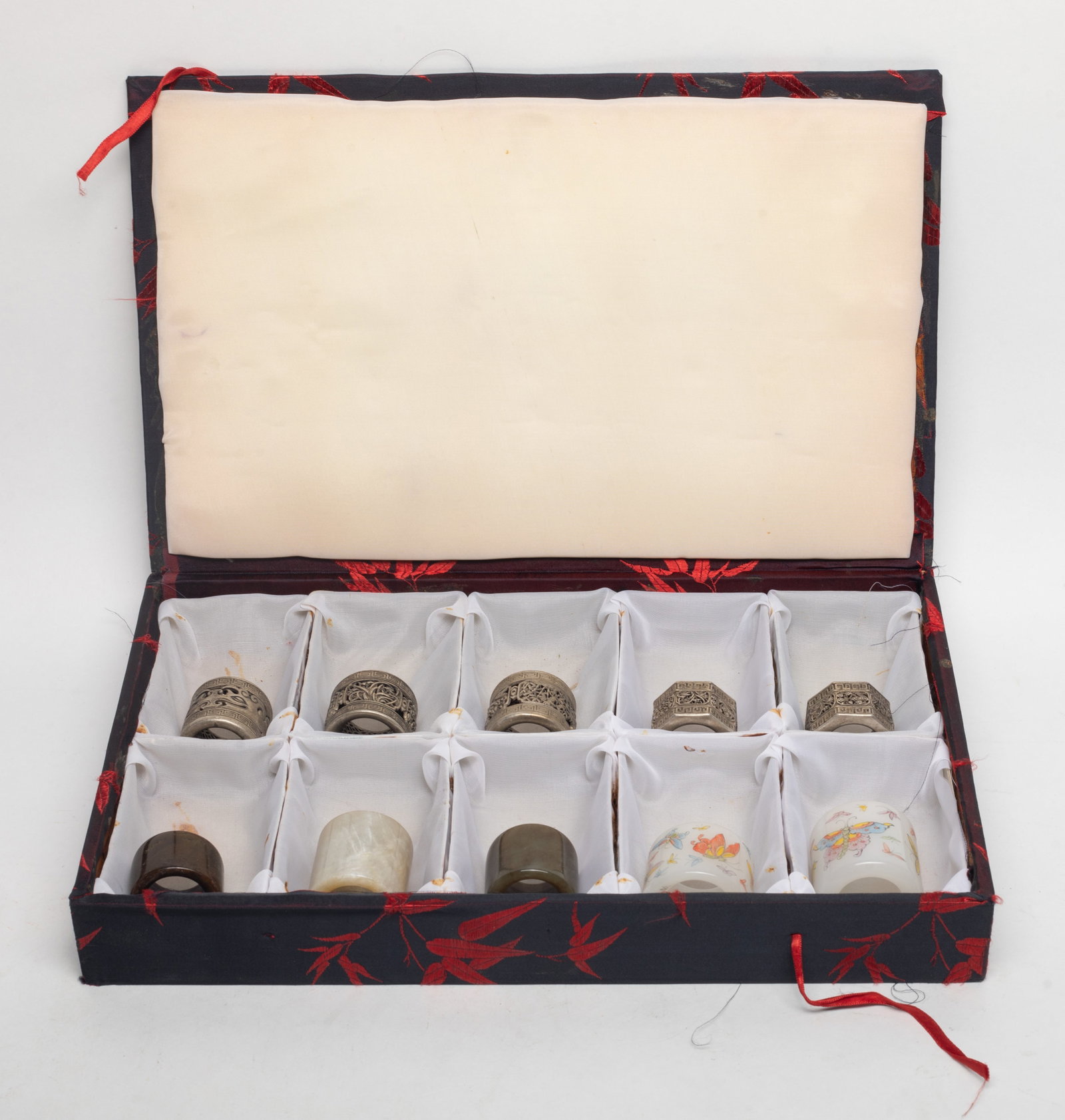 Estate Set of Chinese Thumb Rings: Set of ten Chinese metal, glass and stone thumb rings, with box. Size varies.