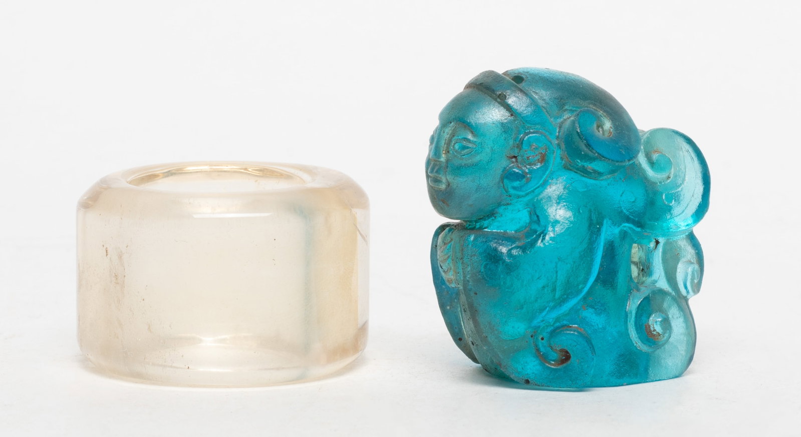 Chinese Rich Crystal Ring, Glass Figure: Chinese clear crystal thumb ring and blue glass stylized figure sculpture. Approx. 1.5*1.6*1.17 inch (glass size).