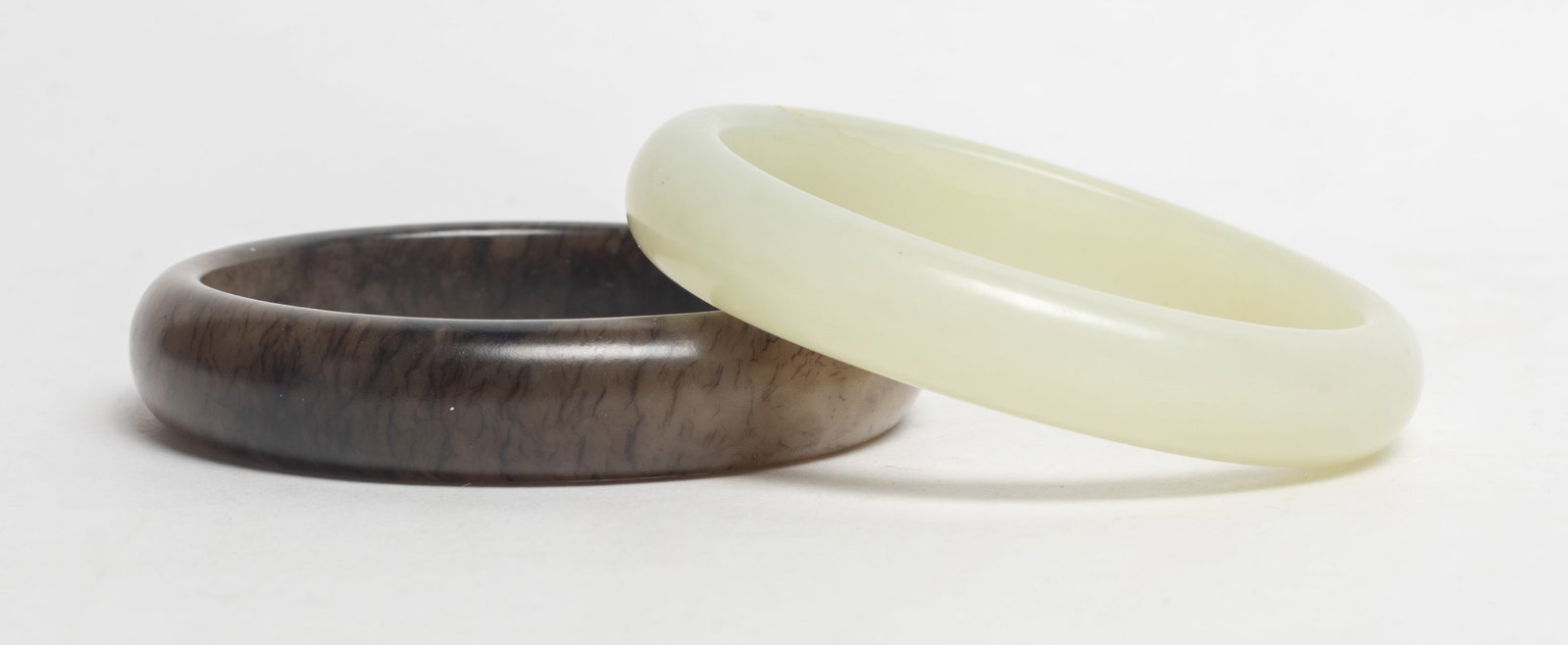 Two Chinese Jade Carved Bangles: Two Chinese jade bangles. Approx. 2.65 inch outer diameter, 2.15 inch inner diameter (larger).