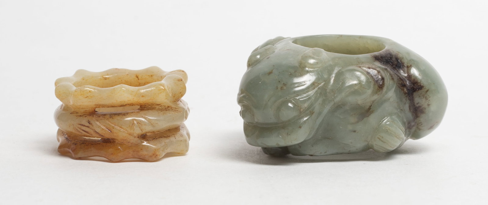 Estate Two Chinese Jade Thumb Rings: Two Chinese jade thumb rings, one of beast form and the other of bamboo form. Approx. 2.15*1.7*1 inch (larger).