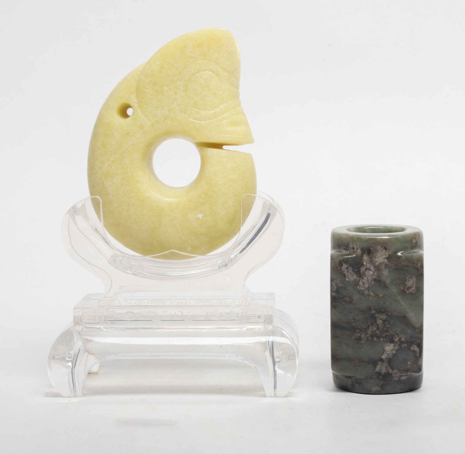 Two Chinese Jade/ Hard Stone Sculptures: Two Chinese jade / hard stone sculptures, one carved of archaic pig-dragon form, with stand, the other of cong form. Approx. 3.2*2.4*1 inch (larger).