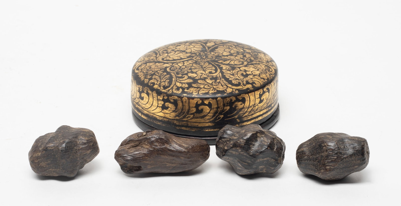 Chinese Wood Beads w/ Lacquer Box: The lacquer box of rounded form, applied overall in black glaze highlight with gold colored floral pattern, the box includes four wood nuggets, with fragrant. 2.14*0.99 inch (larger nugget); 65g