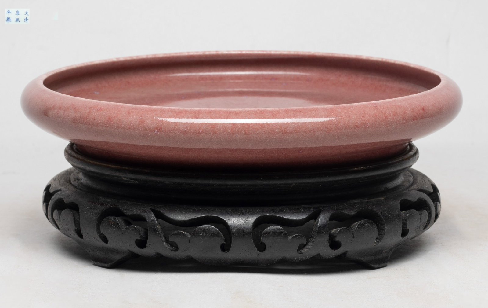 Chinese Red Glazed Porcelain Lg Brush Washer: Large shallow porcelain brush washer, the inside and out covered with mottled soft red glaze, the bottom marked with six characters, with stand. Approx. 8*1.35 inch (w/o stand). The Estate of DTLA, 20