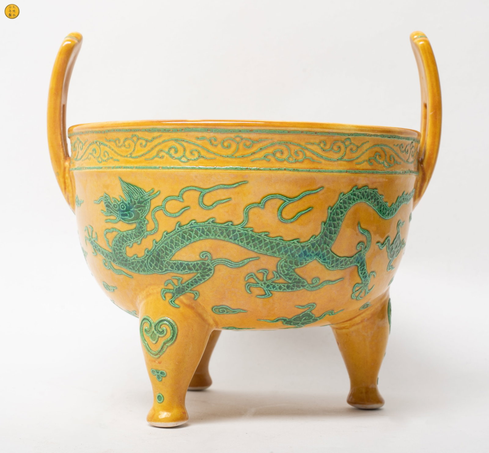 Chinese Export Porcelain Censer: The censer raised by a tripod feet, with a pair of upright handle, the exterior carved with sinuous dragon and clouds motifs in green tone, the glaze stop at the foot, incised with a six-character mar