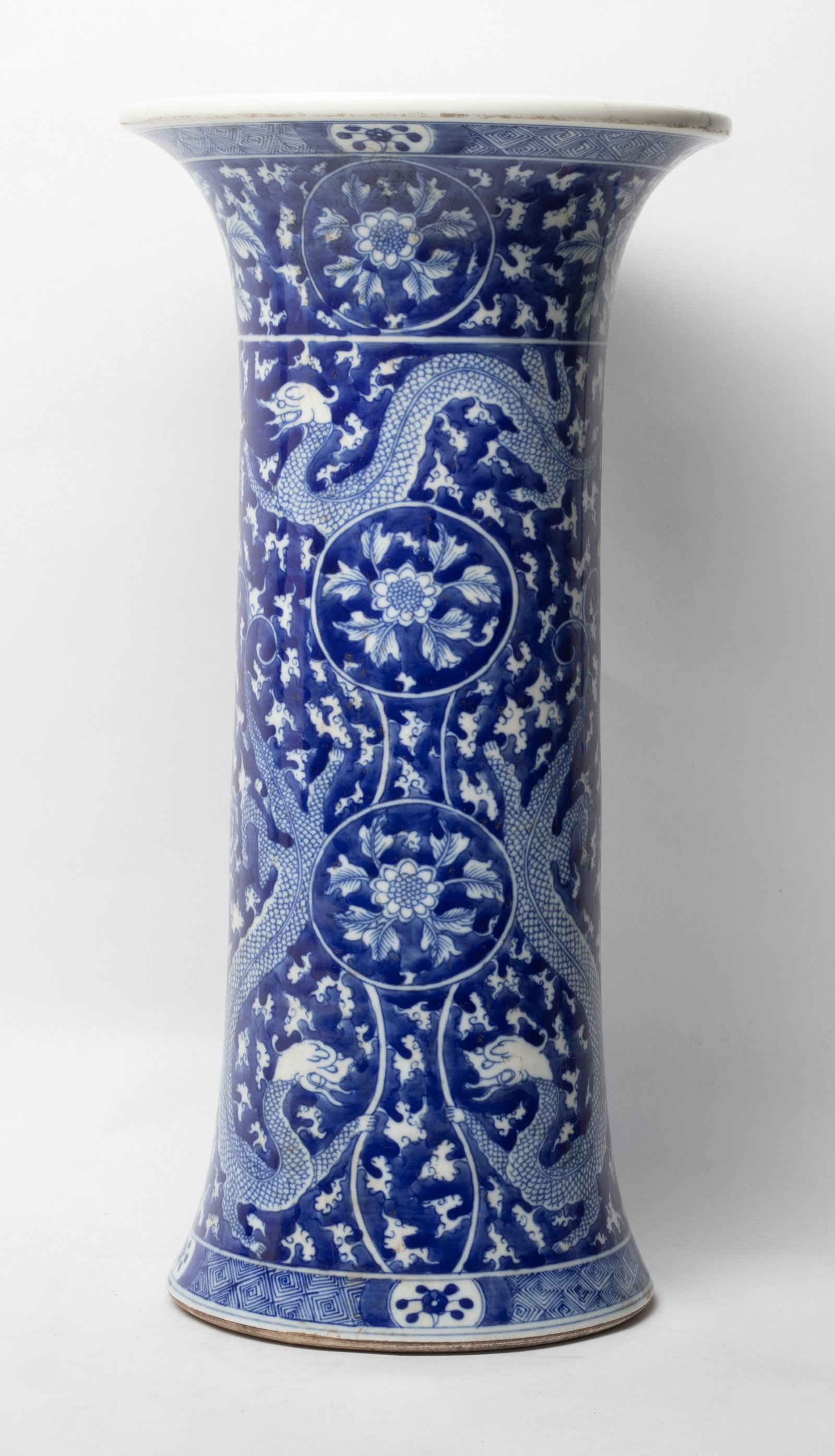 Tall Chinese Export Porcelain Vase: Tall Chinese export porcelain vase, of long cylindrical form with a flared rim, the exterior body painted in cobalt blue tone of dragon and blossom floral motifs, the glaze stop at the base. Approx. 7