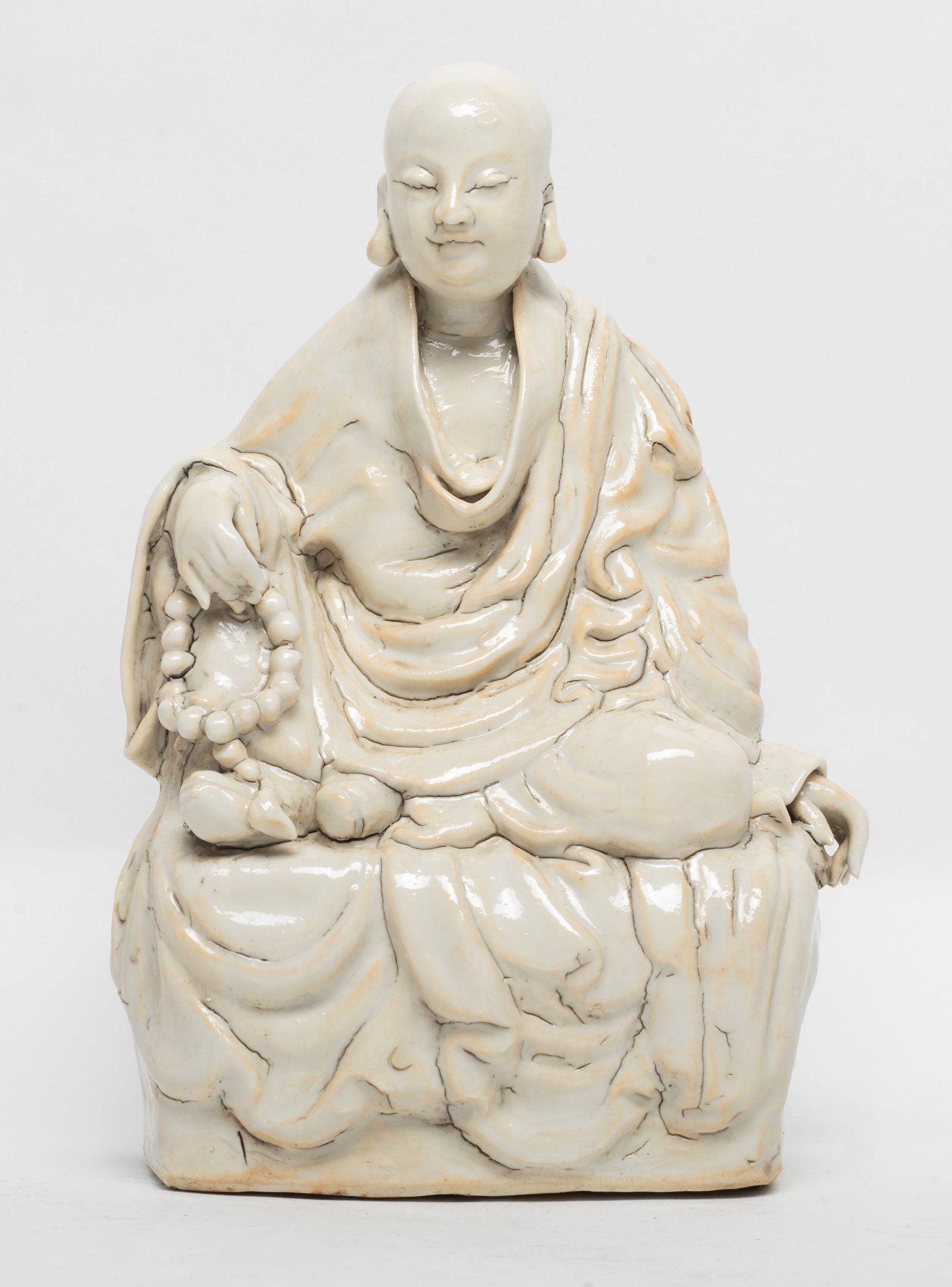 Chinese Hutian Ware Porcelain Buddha: Seated porcelain Buddha, with one hand resting on his raised right knee and the other resting on his side lying leg, with smiling expression. Approx. 5.5*8.3 inch
