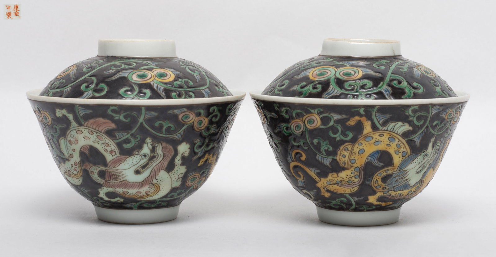 Chinese Export Porcelain Tea Cups: A pair of porcelain tea cups, each painted with a sinuous dragons amidst floral scroll motif, with a matched lid, the base inscribed with a reign mark. Approx. 4.1*3.3 inch (with lid)