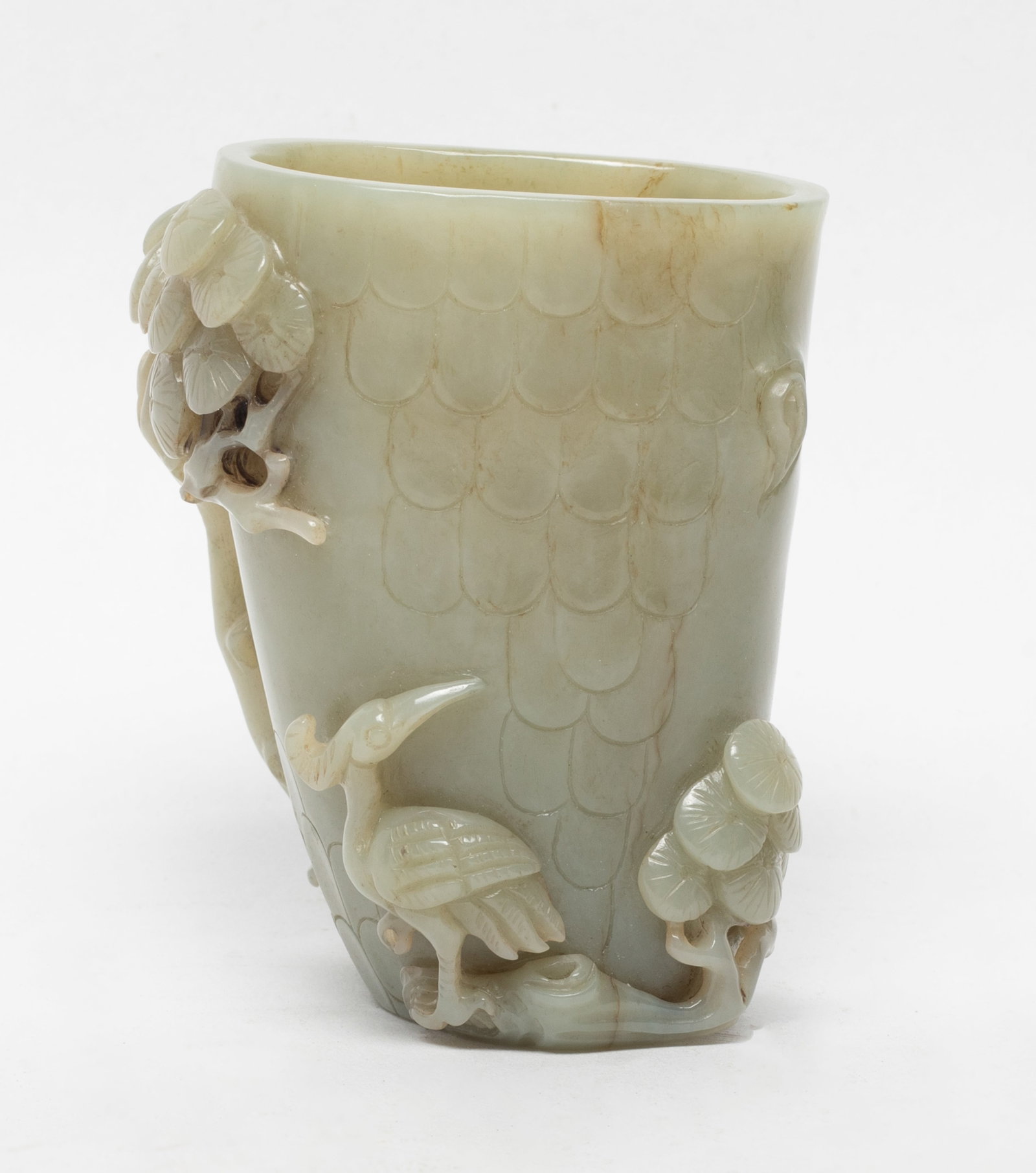 Chinese Jade Carved Vase: Well worked as a tall body with upright petals forming the walls of the vessel, the pine tree further depicted borne and supported on a gnarled leafy branch issuing two smaller blooms and crane. Appro