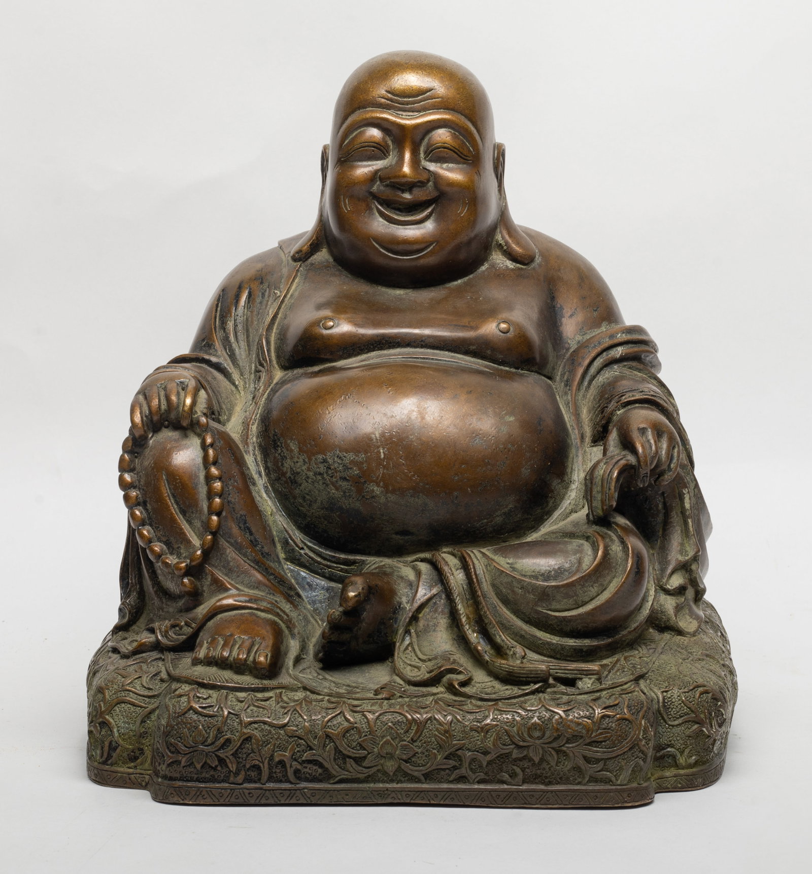 Large Chinese Bronze Sculpture of Buddha: Carved as Buddha in a sitting position, with laughing expression and a pair of pendulous ears, wearing a loose robe opening at his chest and big belly, right hand holding beast. Approx. 9*10.5*9.2 inc