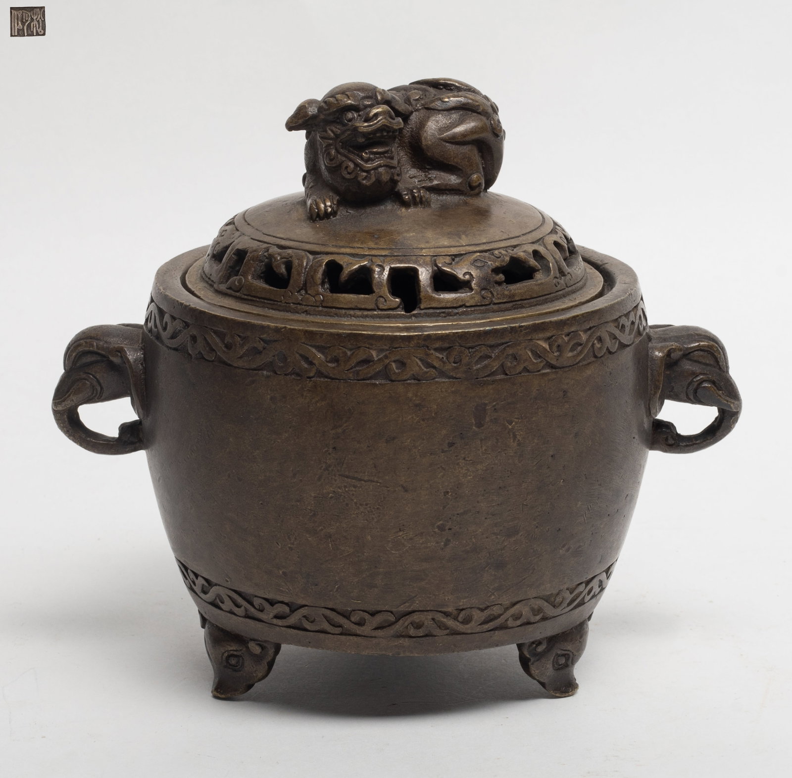 Chinese Bronze Cabinet Censer: Chinese bronze cabinet censer, supported on a tripod feet, flanked by a pair of elephant head handle, the top lid ending with a beast on atop. Approx. 6.3*5.5 inch