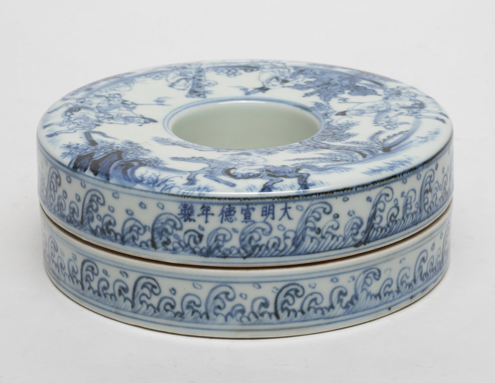 Chinese Blue & White Porcelain Box: Chinese blue and white porcelain box, carved in the form of circular shape, with an open aperture, the exterior painted with warriors ridding horse scene. Approx. 2.1*6.5 inch