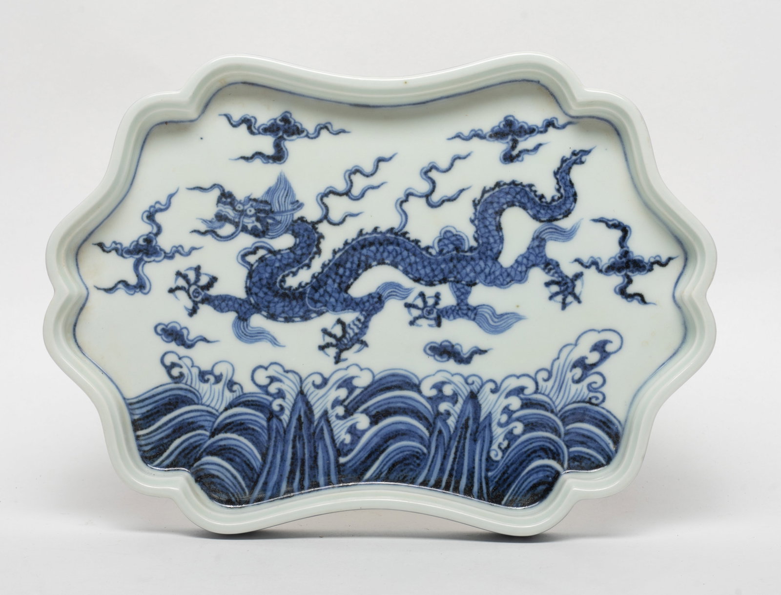 Chinese Export Porcelain Dragon Plate: Chinese export blue and white porcelain plate, the interior painted with a five-clawed dragons amidst clouds and ocean waves, the glaze stop at the base. Approx. 8.8*6.5 inch