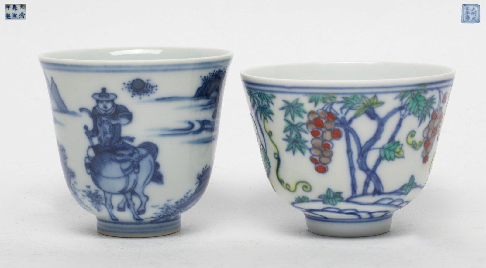 Two Chinese Export Porcelain Cups: Group of two Chinese export porcelain cups, one painted with grape fruit motif, and the other painted with continuous landscape scene detailed with mountain, rock and figure, both with mark. Approx. 2