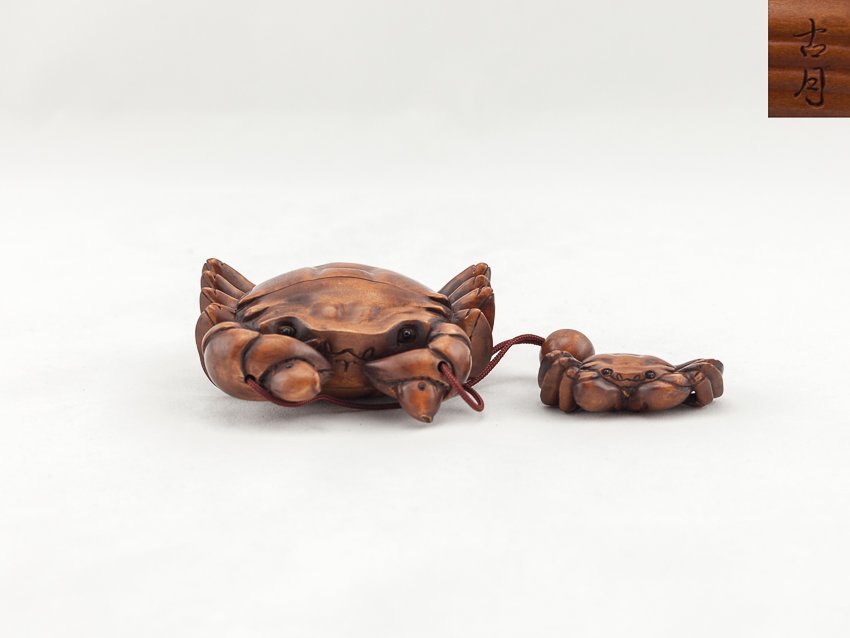 Antique Carved Box Wood Inro:Crab: Vividly detailed carved 2 case box wood antique inro; of a crab holding two fishes in both its claws, inlaid eyes on carb and fishes, with a box wood carved netsuke crab and a box wood ojimi, signed. 