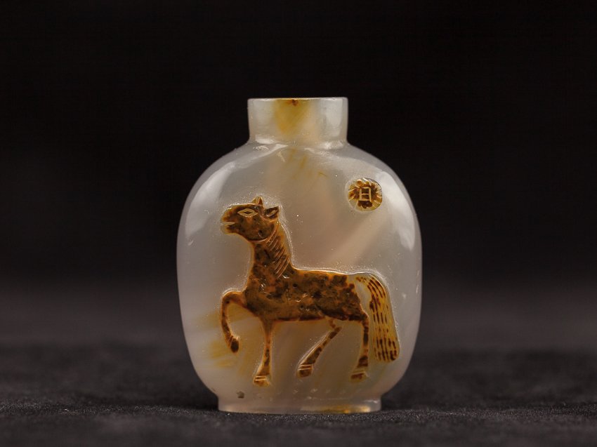 Chinese Antique Carved Agate Snuff Bottle: Rare and antique snuff bottle of ovoid form, one side carved of a horse under the sun. Late 18th/early 19th century. 5.5cm high (with stopper)