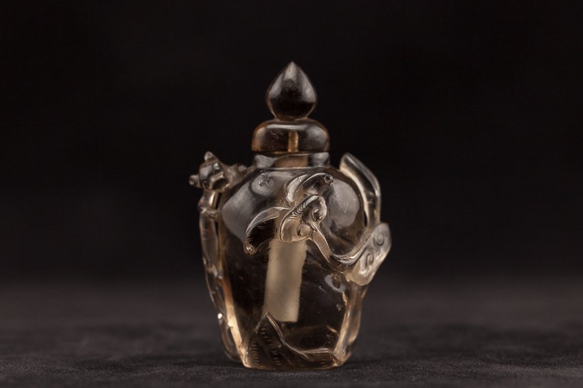 Chinese Antique Tea Crystal Snuff Bottle: Antique carved tea crystal snuff bottle; flattened urn form, flanked by a chilong handle to one side; 19th century. 7.6cm high (with stopper)