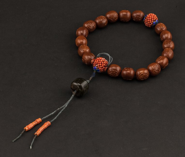 Chinese Antique Carved Nuts Prayer Beads: Comprising of twenty beads, eighteen main beads are all 19th century carved nuts beads, spaced by two coral beads, a tourmaline suspending on the top beads, terminating in two seed coral dewdrops togg