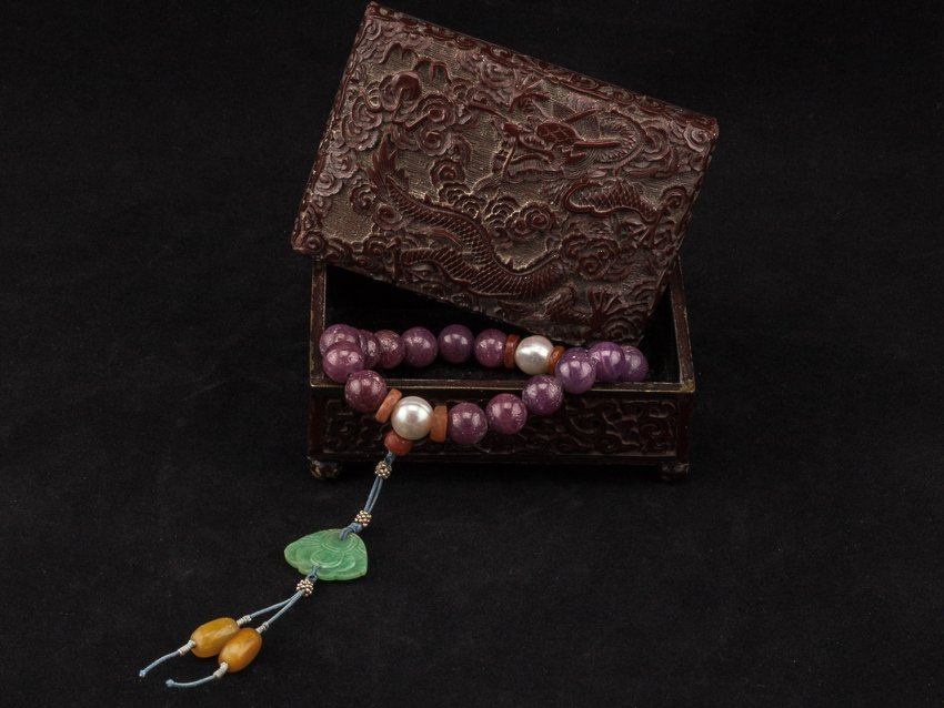 Late 19th Chinese Antique Ruby Prayer Beads: Comprising of twenty beads, eighteen main beads are 19th century uncarved red ruby beads and spaced by two pearl beads, a carved Burma jade button suspending on the top beads, terminating in two seed