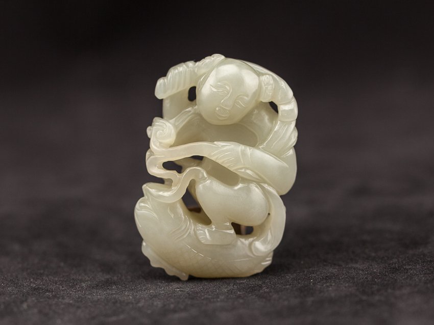 Chinese Antique Pale Celadon Jade Boy: Late 18 Early 19TH Pale Celadon Jade Boy; lightly greenish-color, of a squat boy holding a LimChi with a big leaf which had an Chinese Character carved on, beneath the boy is a upside down carp formin