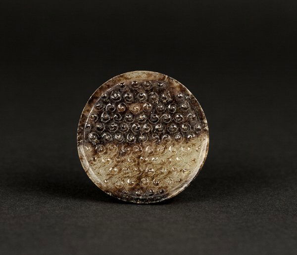 Han Style Chinese Antique Jade Pommel: Of circular section, the domed center incised with a field of raised comma spirals, the underside with a circular channel for attachment, in grey color with brown suffusions.Han Style. Diameter: 5 cm