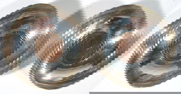 Pair of shaped silver dishes by A.E. Jones, set w: Pair of shaped silver dishes by A.E. Jones, set with copper coins to the bases, Birmingham 1939, each 10cm diameter