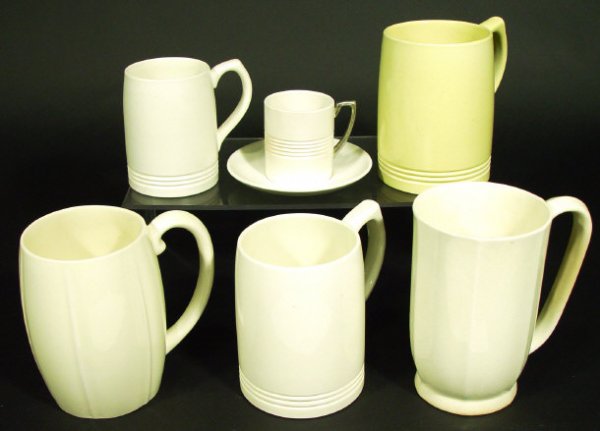 Five Wedgwood Keith Murray tankards and a coffee: Five Wedgwood Keith Murray tankards and a coffee can and saucer, each with cream and matt straw glazed decoration, factory marks and signatures to the bases of each, the largest 13cm high