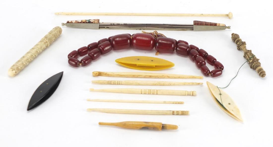 Sewing items and a string of cherry amber coloured: Sewing items and a string of cherry amber coloured beads including carved ivory and bone needle cases