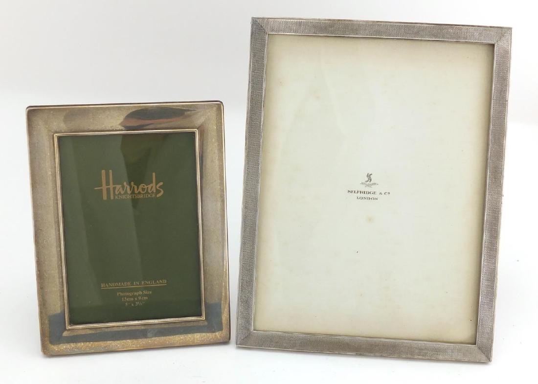 Two rectangular silver easel photo frames, retailed by: Two rectangular silver easel photo frames, retailed by Selfridge & Co and Harrods, the largest with engine turned decoration 23cm x 17.5cm