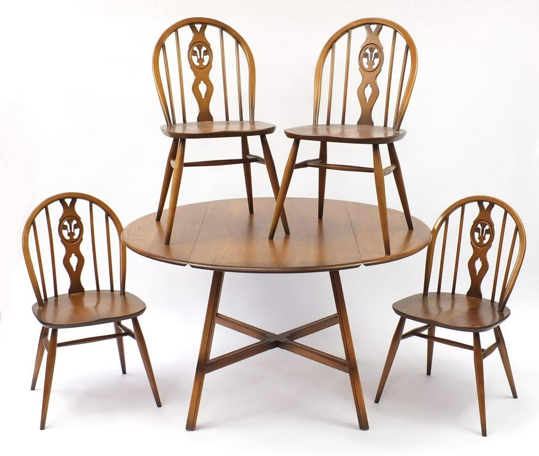 Ercol elm dining table and four chairs, the table 72cm: Ercol elm dining table and four chairs, the table 72cm high x 62.5cm in diameter
