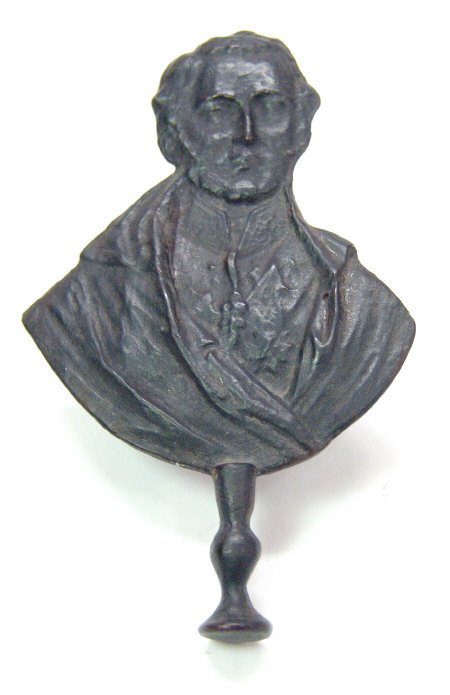 Cast metal pipe tamper in the form of a political b