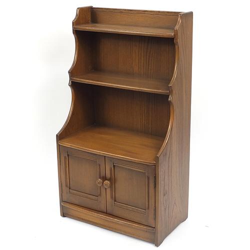 Ercol elm waterfall bookcase with cupboard base, (1353) on Feb 18, 2022 Eastbourne Auctions