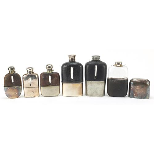 Six antique and later hip flasks, five with leather mounts, the largest 18cm high: Six antique and later hip flasks, five with leather mounts, the largest 18cm high