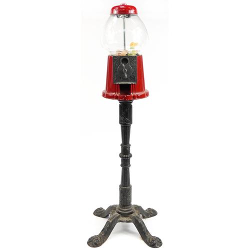 Vintage red painted metal and glass bubble gum vending machine raised on a cast iron base, Carousel: Vintage red painted metal and glass bubble gum vending machine raised on a cast iron base, Carousel Industries label to the base, 97cm high